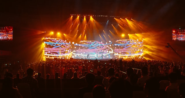 Multitud de jóvenes disfrutando de un concierto de música con luces de escenario coloridas